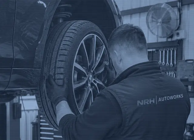 A mechanic refitting a wheel to a car on the lift in our workshop